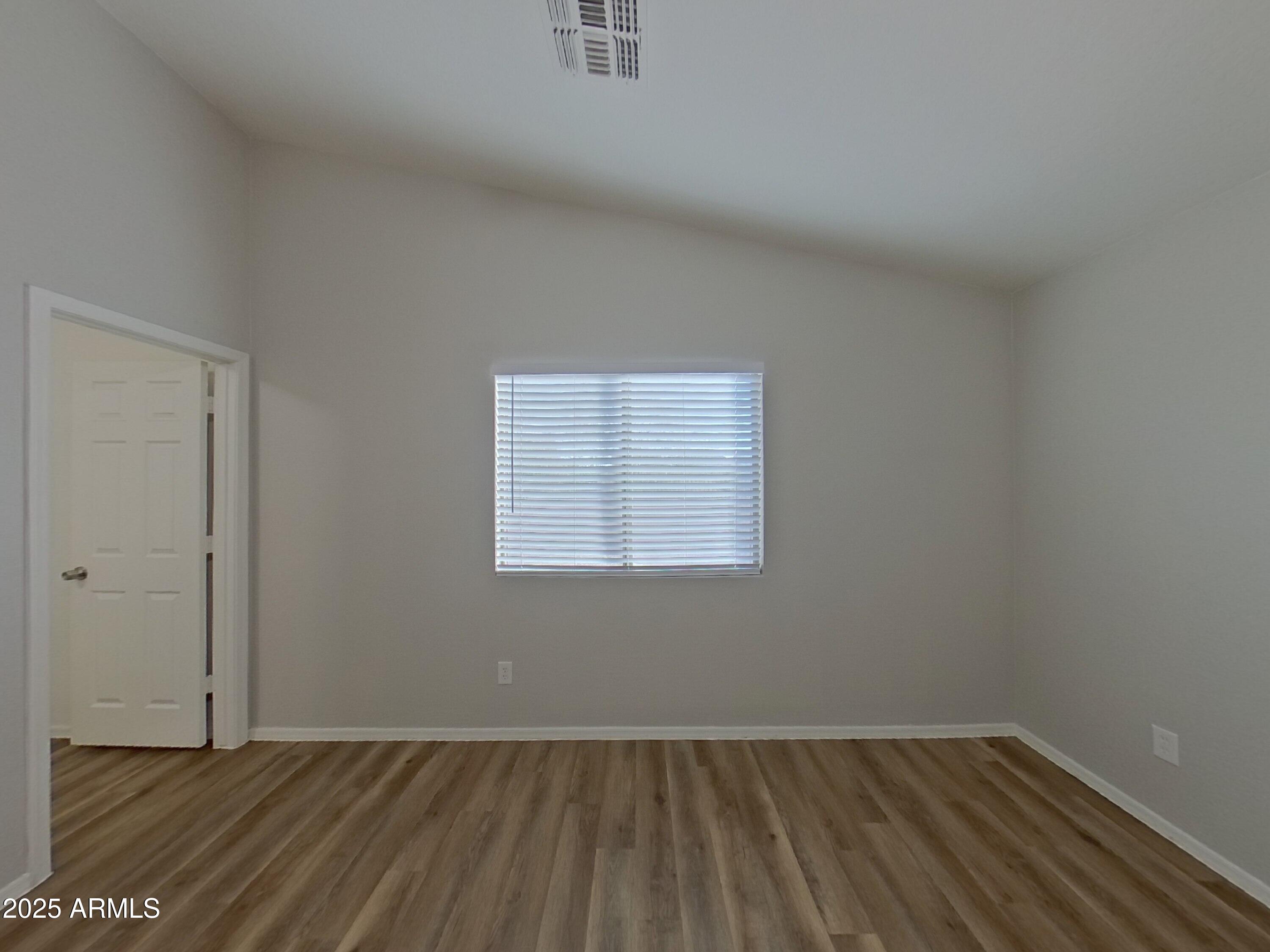 19303 North Leland Road Maricopa, AZ 85138 - Photo 8 of 16 an empty room with wooden floor and windows