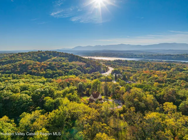 a view of a white house next to a yard with potted plants