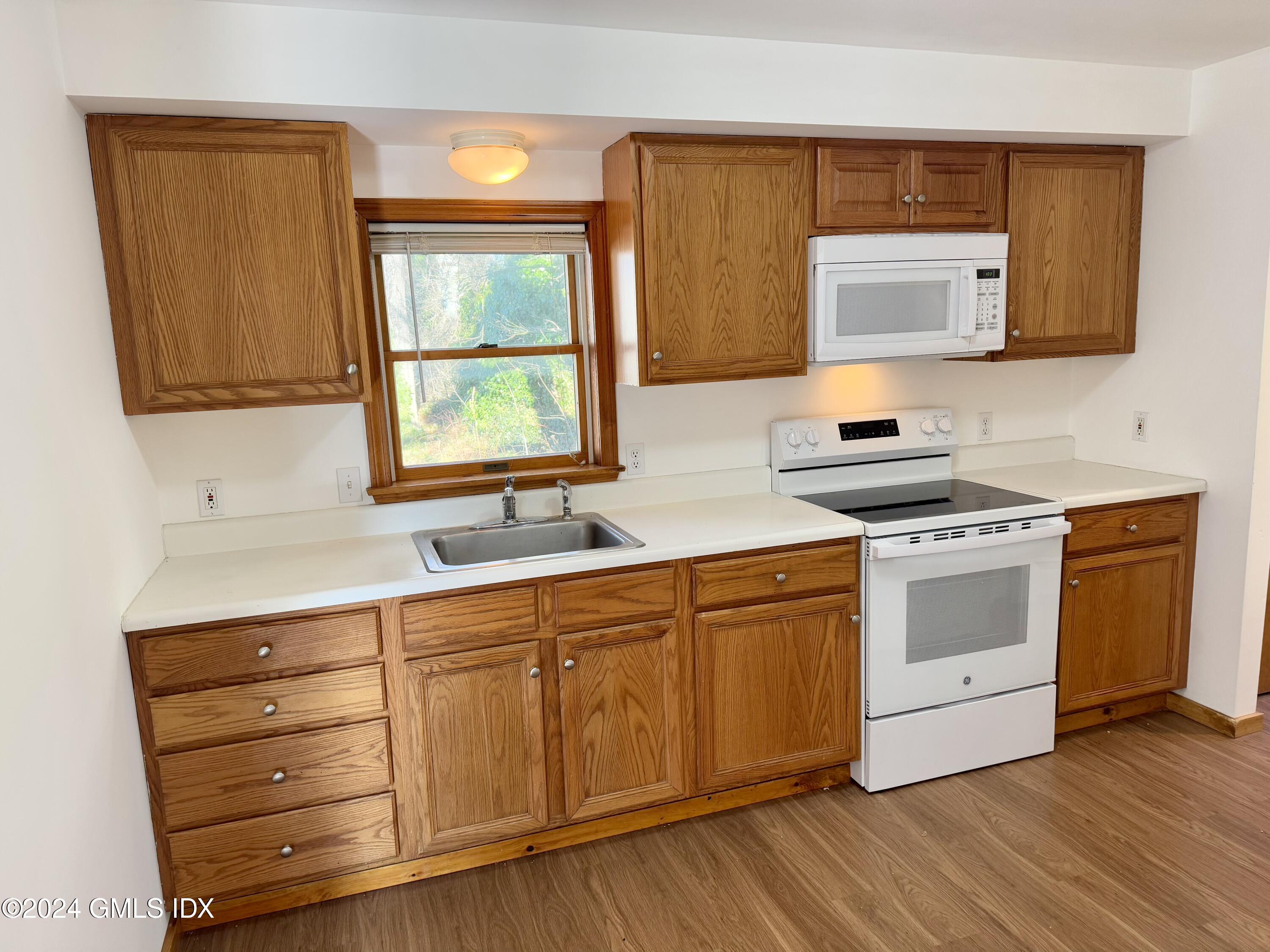 a kitchen with stainless steel appliances a stove microwave and sink