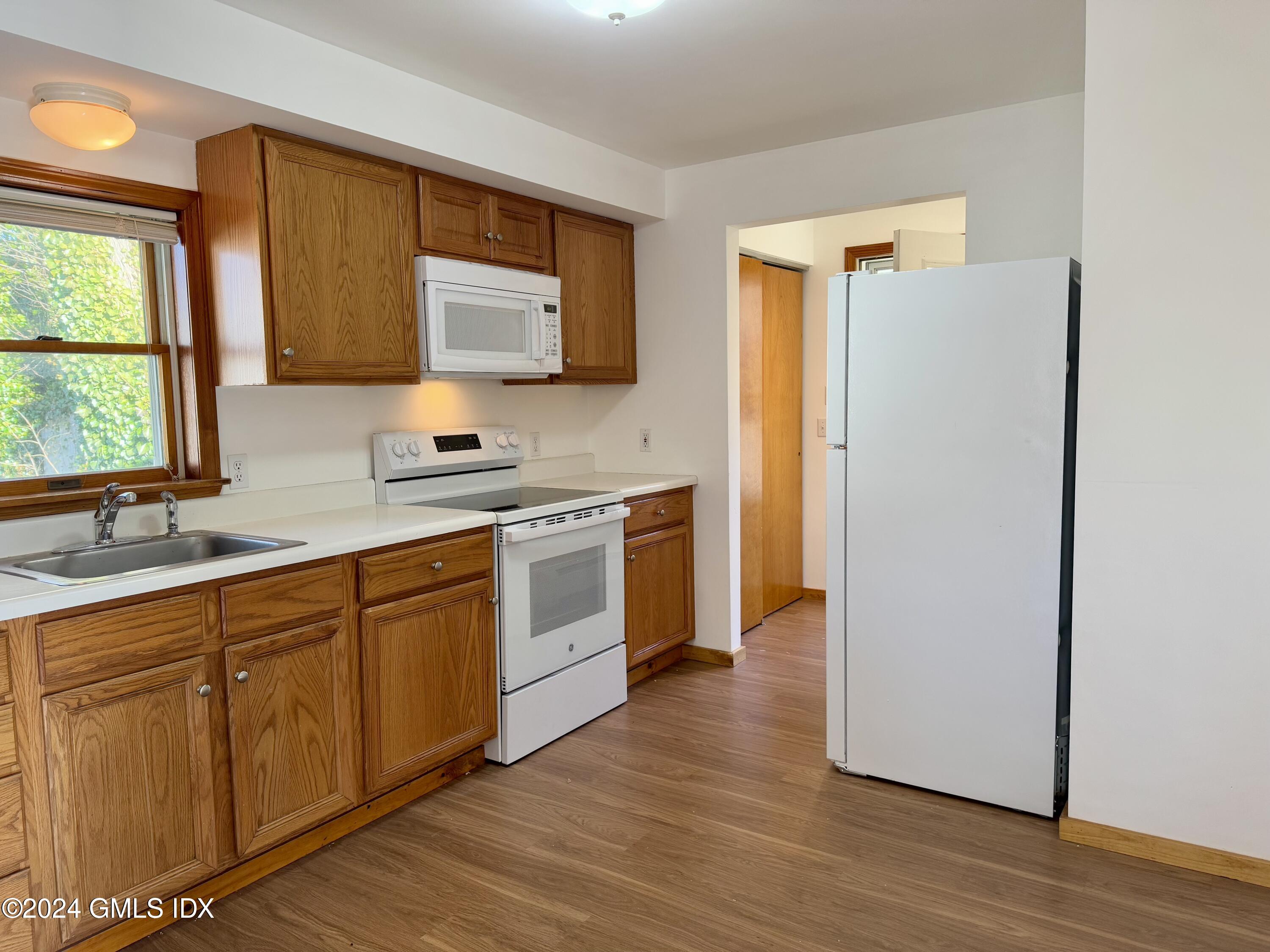 137 South Water Street, Unit 1B Greenwich, CT 06830 - Photo 10 of 13 a kitchen with stainless steel appliances a sink cabinets and a window