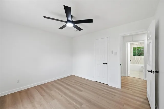 a view of a room with wooden floor closet and windows