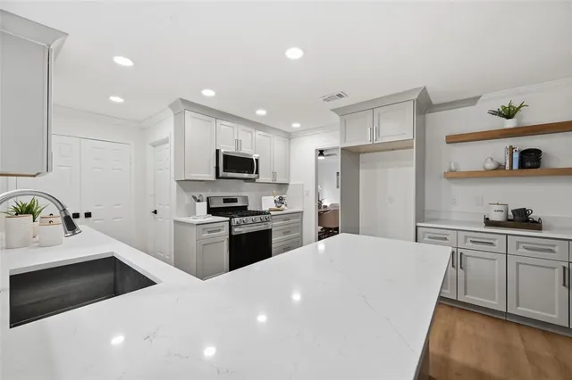 a kitchen with stainless steel appliances a stove sink microwave and cabinets