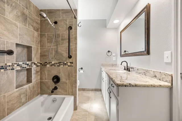 a bathroom with a granite countertop sink a mirror and shower