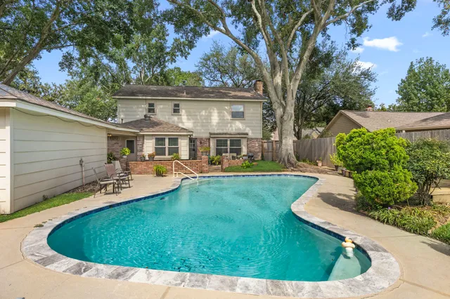 a view of house with swimming pool outdoor seating