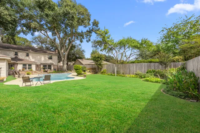 a view of a house with backyard and sitting area