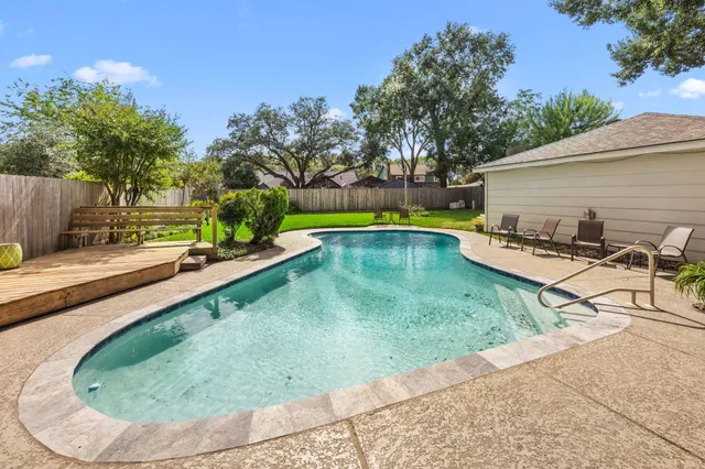 a view of a backyard with swimming pool