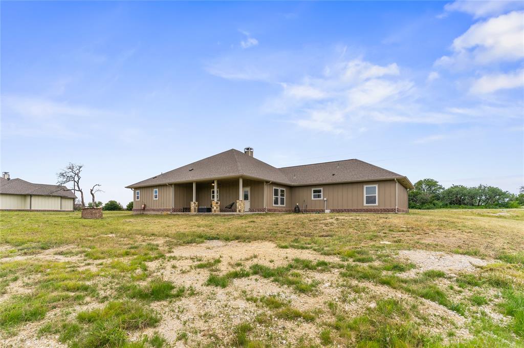 139 Kriston Lane Springtown, TX 76082 - Photo 29 of 39 Spacious single-story residence with a covered patio, tan siding, and a brown shingle roof