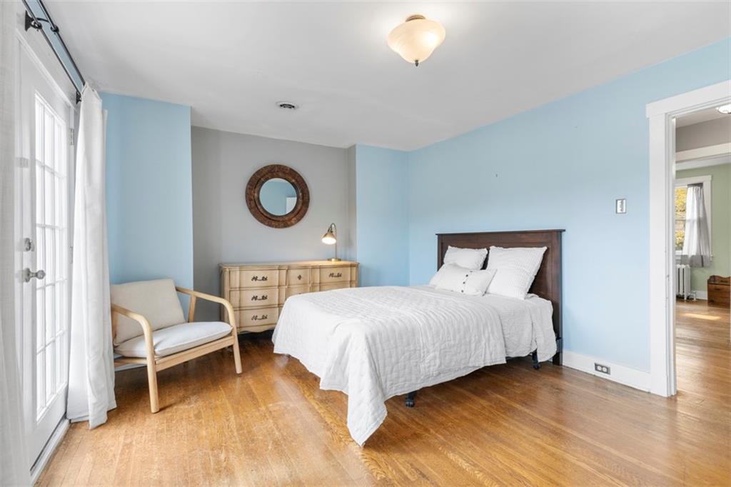 1141 Chislett Street Pittsburgh, PA 15206 - Photo 13 of 34 a bedroom with a bed and a lamp