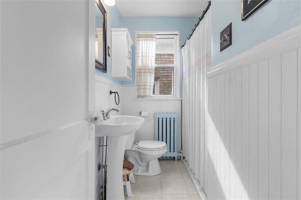 1141 Chislett Street Pittsburgh, PA 15206 - Photo 16 of 34 a bathroom with a sink toilet and a mirror