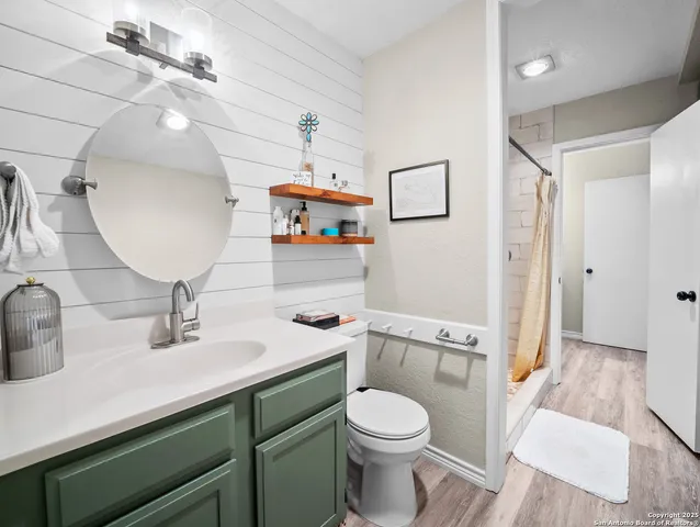 a bathroom with a sink a toilet and shower curtain