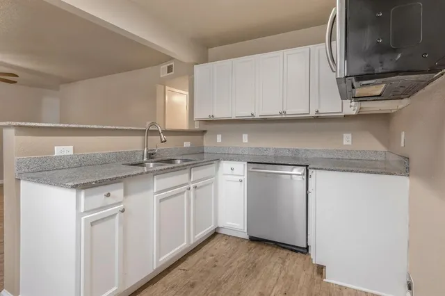 a kitchen with sink stove and cabinets