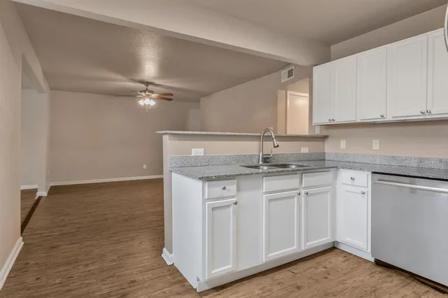 a kitchen with granite countertop a sink and cabinets