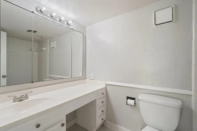 a bathroom with a sink a toilet and a mirror