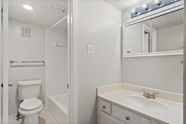 a bathroom with a sink vanity and toilet