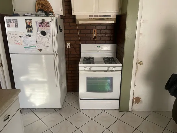 a white refrigerator freezer and a stove sitting inside of a kitchen