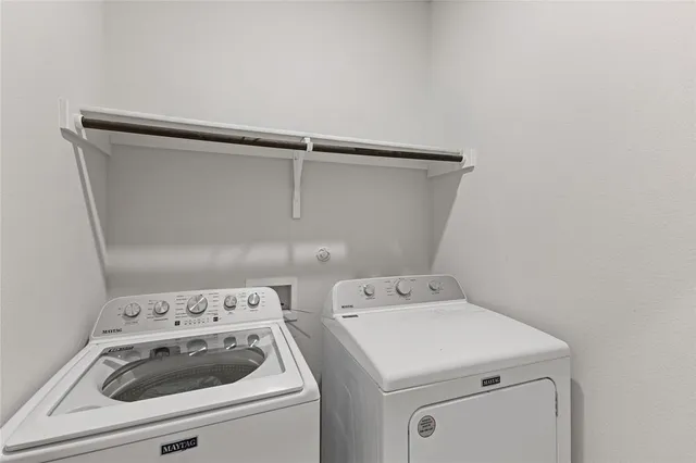 a view of washer and dryer with bathroom in the background