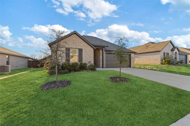 a front view of a house with a garden and yard