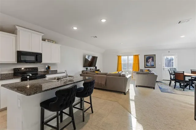 a kitchen with a dining table chairs and a computer