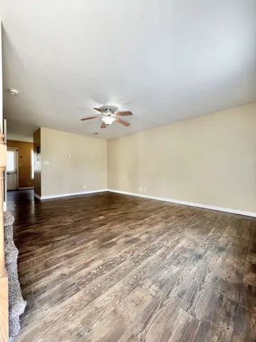 a view of a room with wooden floor and ceiling fan