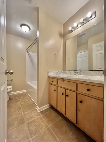 a spacious bathroom with a granite countertop sink mirror and a
