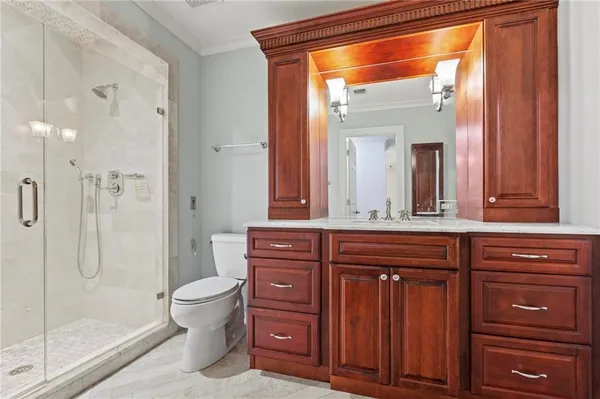 a bathroom with a granite countertop sink toilet a mirror and shower