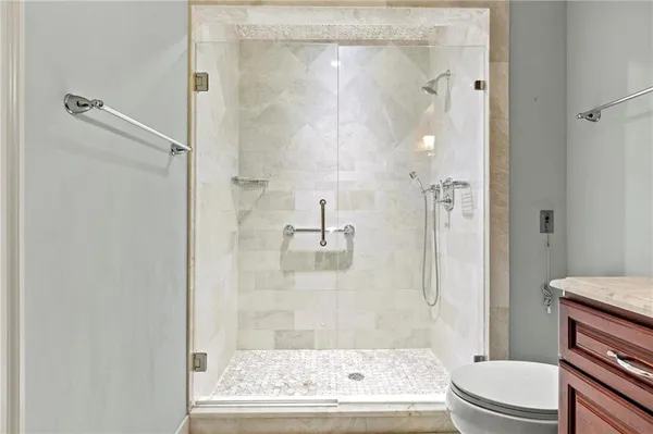 a bathroom with a granite countertop bathtub shower and toilet