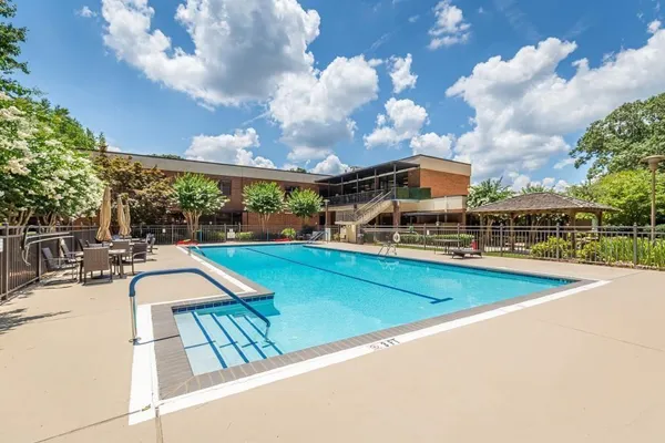 a view of a swimming pool with a patio and a yard