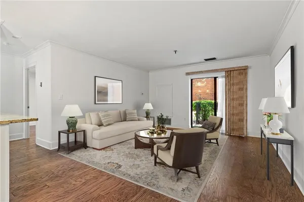 a living room with furniture a large window and wooden floor