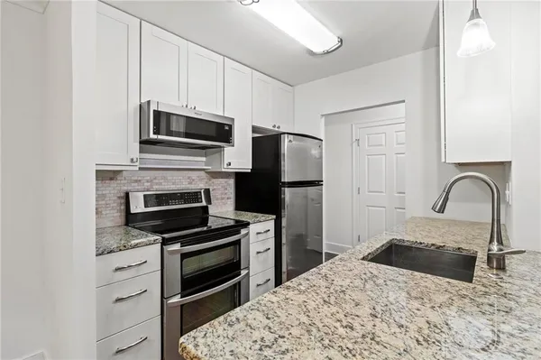 a kitchen with granite countertop a stove and a refrigerator