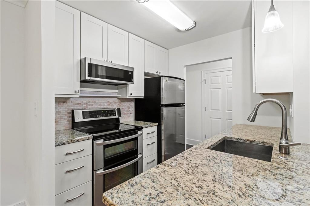 300 Johnson Ferry Road, Unit A110 Atlanta, GA 30328 - Photo 6 of 27 a kitchen with granite countertop a stove and a refrigerator