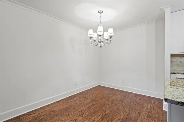 a view of a room with wooden floor chandelier and a window
