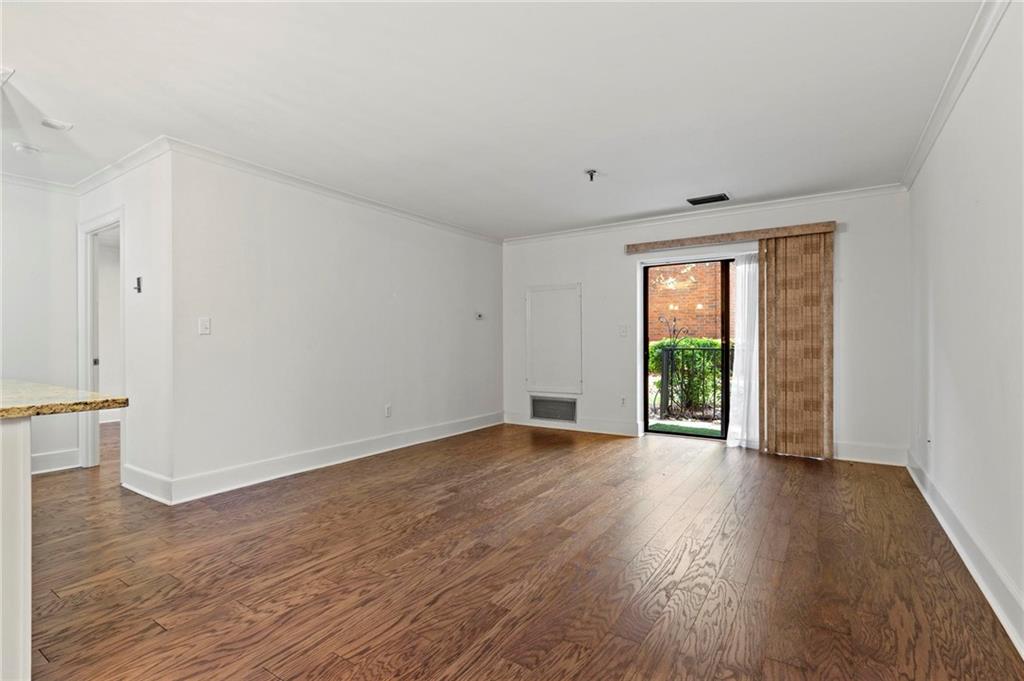 300 Johnson Ferry Road, Unit A110 Atlanta, GA 30328 - Photo 10 of 27 a view of an empty room with wooden floor and a window