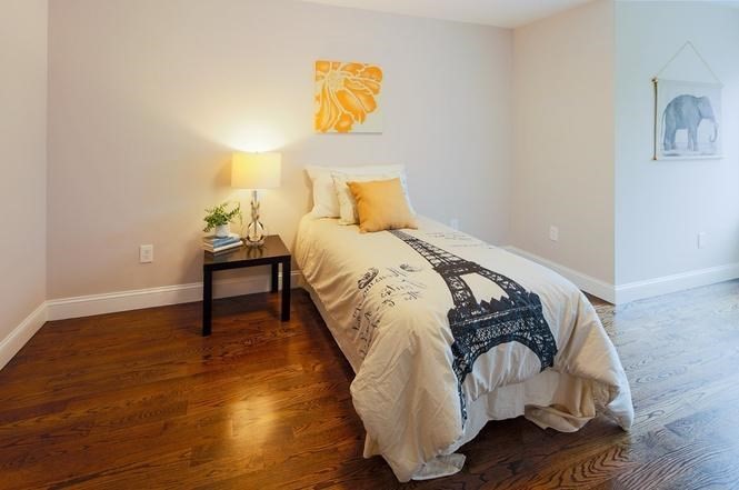 93 Calvary Street, Unit 2 Waltham, MA 02453 - Photo 27 of 33 a bed sitting in a bedroom next to a lamp
