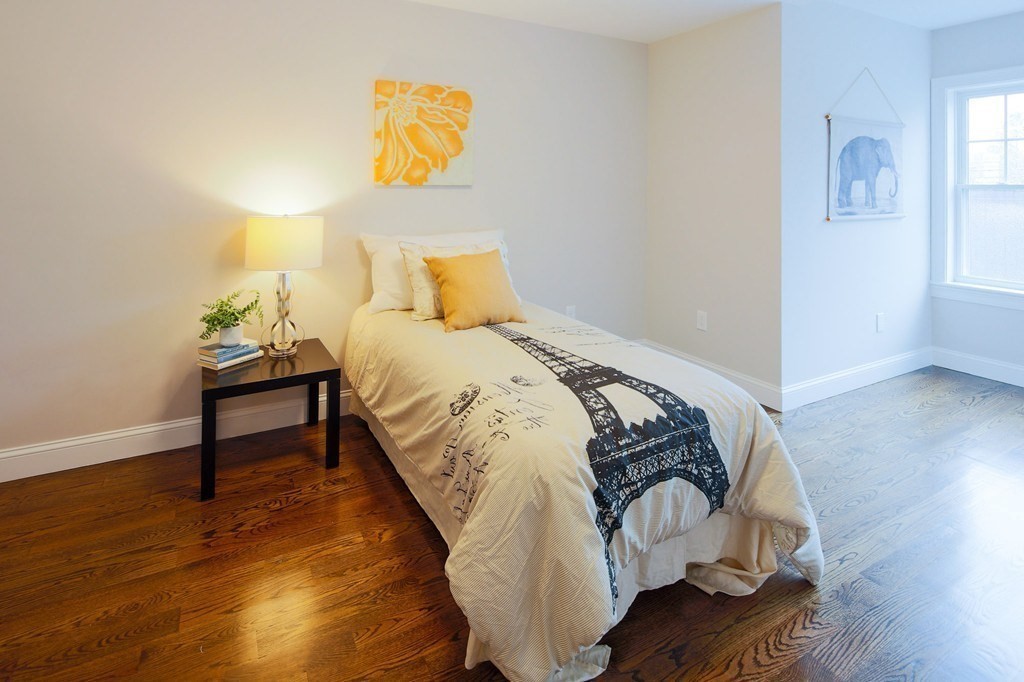 93 Calvary Street, Unit 2 Waltham, MA 02453 - Photo 9 of 33 a bed sitting in a bedroom next to a window