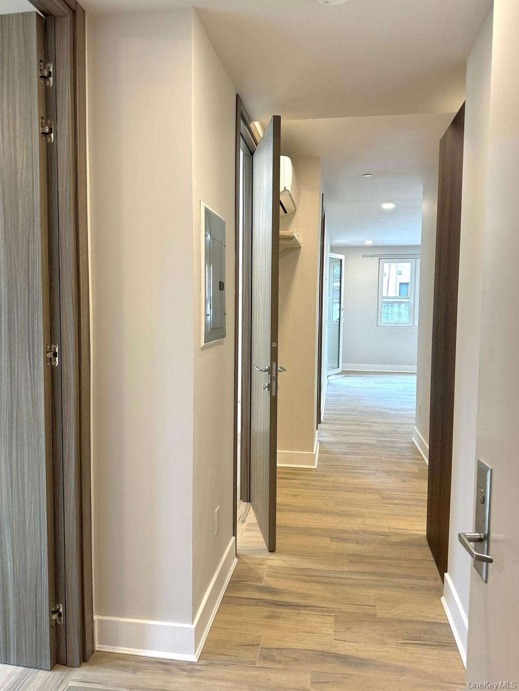 2478 East 11th Street, Unit 2C Brooklyn, NY 11235 - Photo 13 of 16 a view of a hallway with wooden floor and staircase