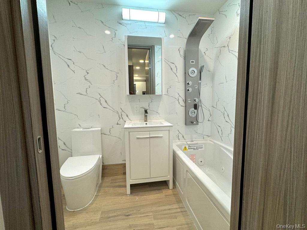 2478 East 11th Street, Unit 2C Brooklyn, NY 11235 - Photo 6 of 16 a bathroom with a sink toilet and shower