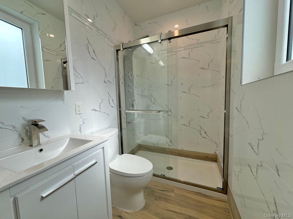 2478 East 11th Street, Unit 2C Brooklyn, NY 11235 - Photo 9 of 16 a bathroom with a shower a sink a toilet and shower