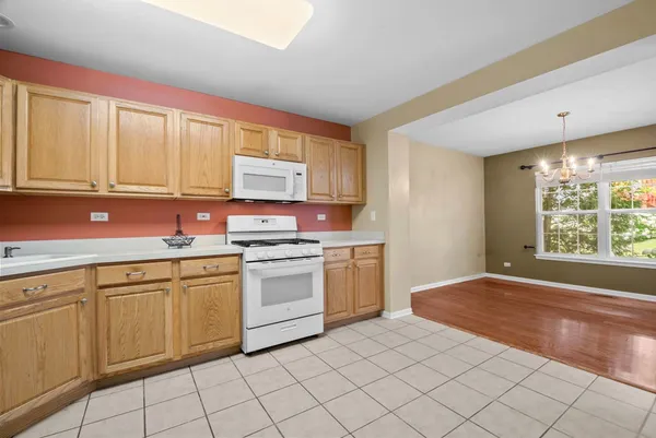 a kitchen with granite countertop white cabinets sink and white appliances