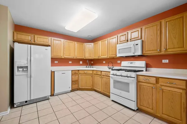 a kitchen with white cabinets and white appliances