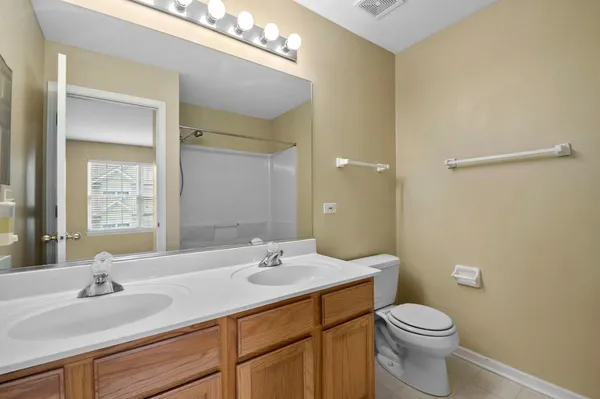 a bathroom with a granite countertop sink a toilet and a mirror