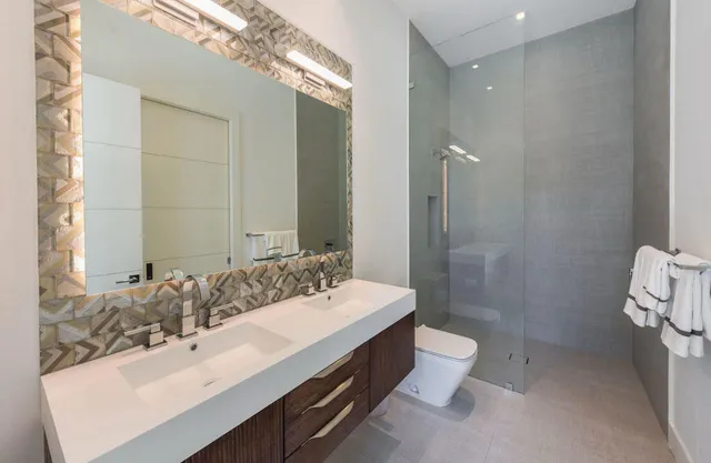 a bathroom with a double vanity sink mirror double and toilet