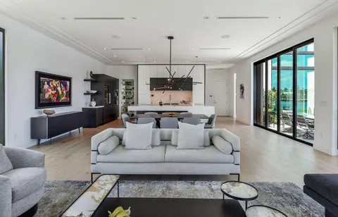 a living room with furniture a flat screen tv and a large window