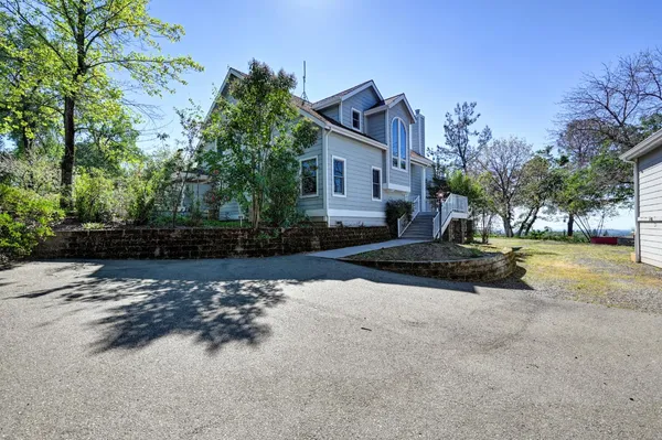 a view of a house with a yard and tree s