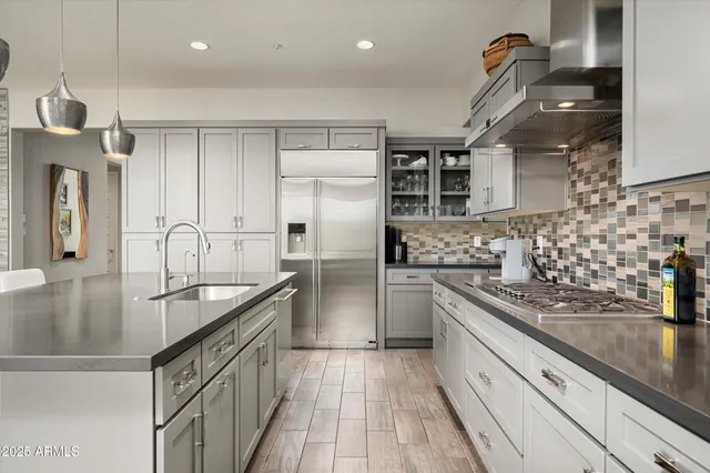 a kitchen with granite countertop stainless steel appliances sink cabinets and window