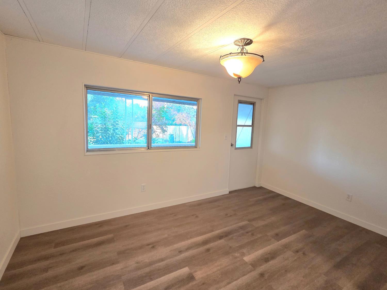 5200 Cavitt Stallman Road, Unit 1 Granite Bay, CA 95746 - Photo 21 of 41 a view of a room with wooden floor and chandelier