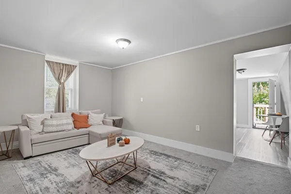 a living room with furniture a rug and a window