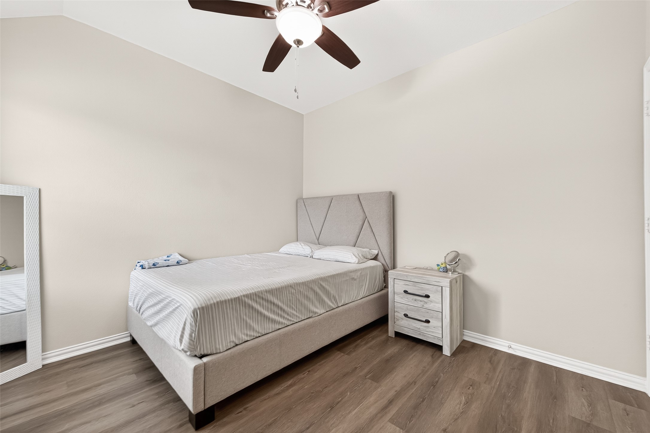 8 Landscape Court Conroe, TX 77301 - Photo 38 of 43 a bedroom with a bed and a chandelier
