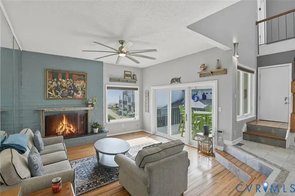 a living room with furniture a fireplace and a floor to ceiling window