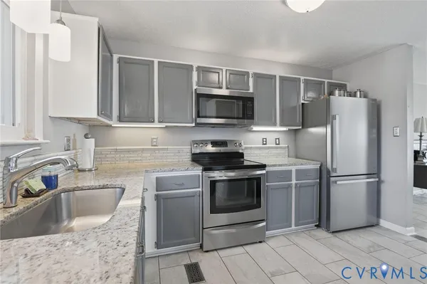 a kitchen with granite countertop a sink stove and refrigerator