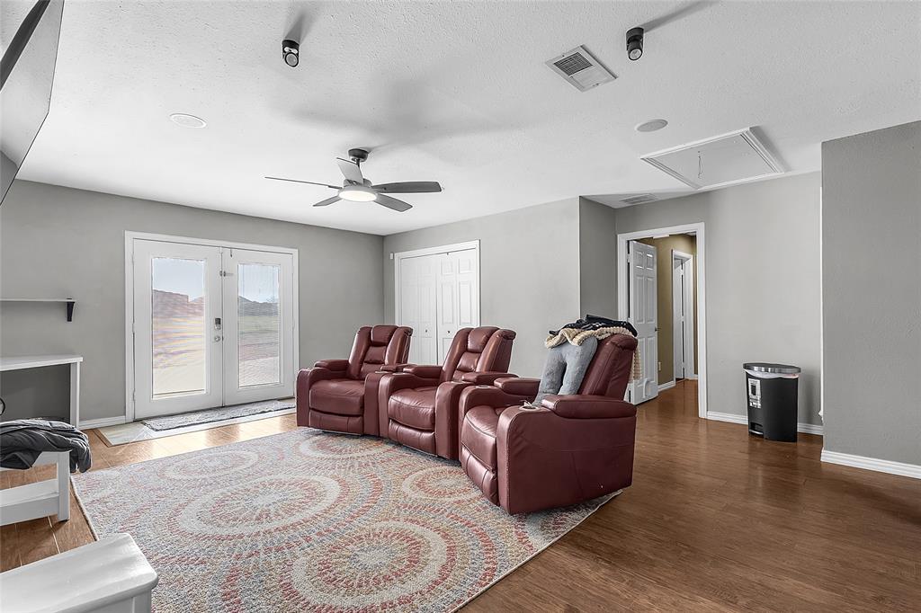 11151 County Road 213 Forney, TX 75126 - Photo 21 of 35 Home theater with wood finished floors, ceiling fan, french doors, and a textured ceiling